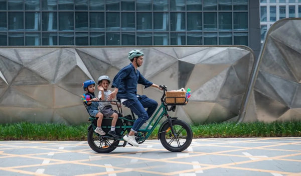 Un hombre lleva a sus dos hijos en una bicicleta eléctrica Fiido T2.