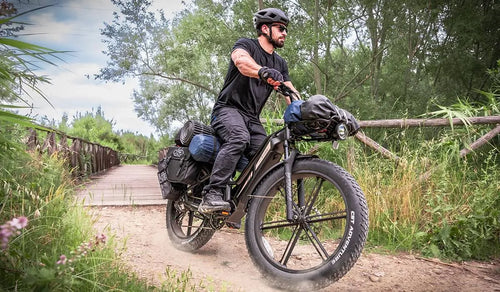 Un hombre conduce una bicicleta eléctrica Fiido Titan por las montañas.