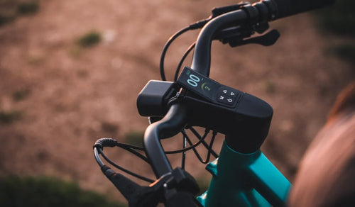 Un hombre está comprobando si la altura del manillar de la bicicleta eléctrica Fiido C21 es adecuada para él.