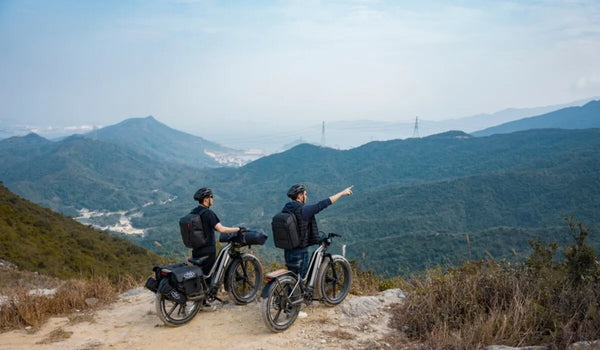 Dos hombres empujan la Fiido Titan por el costado de la montaña.