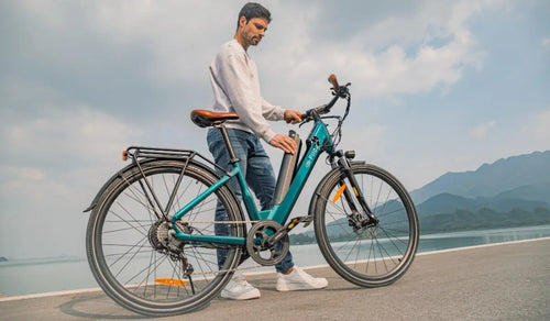 Un hombre desmonta la batería de una bicicleta eléctrica Fiido C11 Pro