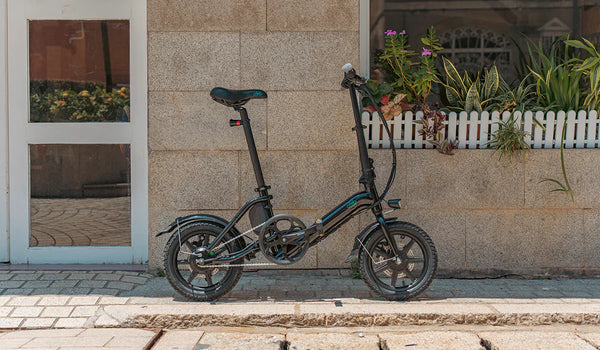  La bicicleta eléctrica Fiido D3pro está de pie junto a la pared.