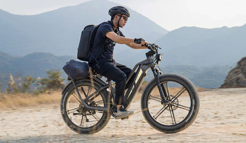 Un hombre conduce una bicicleta eléctrica Fiido Titan todoterreno