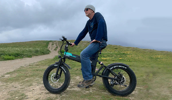 Un hombre conduce una bicicleta eléctrica Fiido M1 Pro en las montañas.