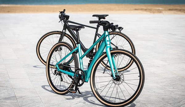 Bicicletas eléctricas Fiido C21 y Fiido C22 estacionadas al borde de la carretera.