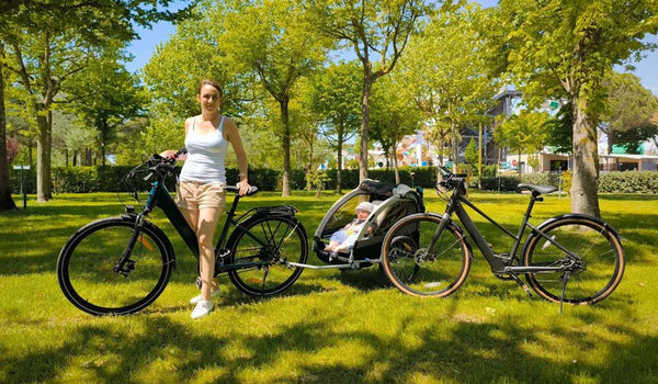 Mujer y dos bicicletas eléctricas Fiido C11 en el parque.