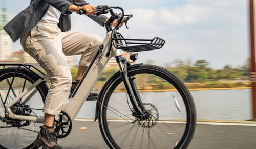 Vrouw die op een Fiido C11 elektrische fiets langs het meer rijdt.