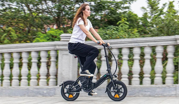 Mujer montando una bicicleta eléctrica Fiido D3 Pro en un puente.