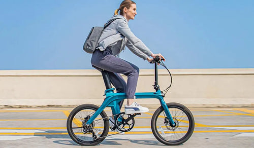 Mujer monta una bicicleta eléctrica Fiido X en la calle.