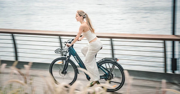 Una mujer circula por la carretera con una bicicleta eléctrica urbana ligera Fiido C11 Pro.