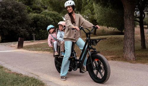 Una mujer monta una bicicleta eléctrica de dos asientos Fiido T2 con sus dos hijos.