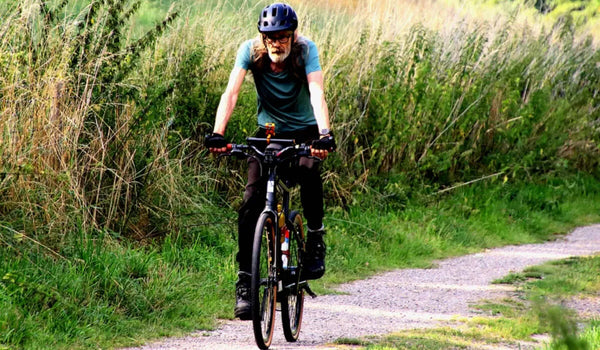 Un hombre montando la bicicleta eléctrica Fiido C21 para hacer ejercicio.