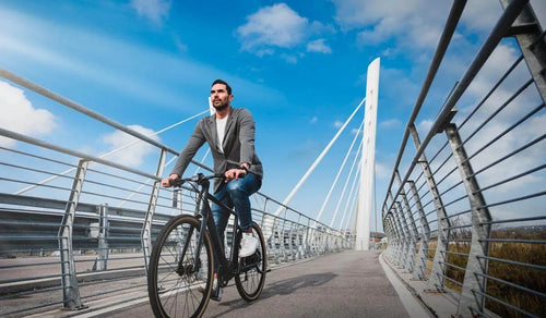 Un hombre monta una bicicleta eléctrica con asistencia de pedaleo Fiido C21 en un carril bici.