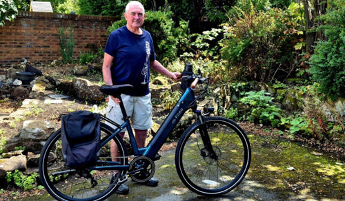 Un hombre mayor tiene una bicicleta eléctrica Fiido C11 Pro.