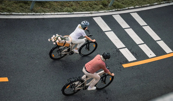 Ambas personas están montando en las bicicletas eléctricas de larga autonomía Fiido Nomads.