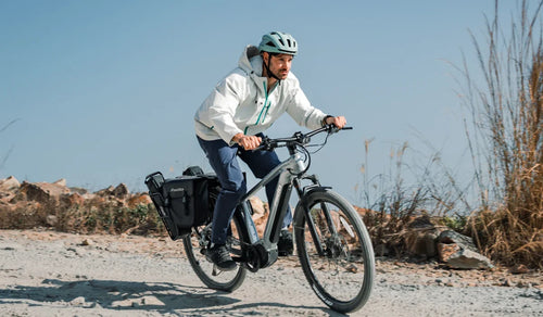 Bicicleta eléctrica de touring Fiido Nomads Pro con un hombre circulando fuera de carretera
