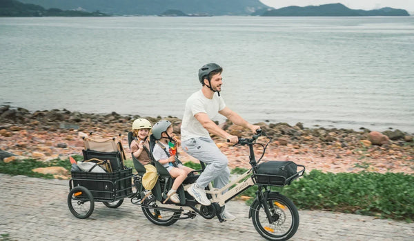 Bicicleta eléctrica de carga longtail Fiido T3 Max transportando a niños con un hombre montando en un día soleado