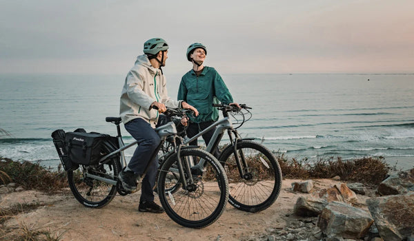 Pareja en bicicletas eléctricas Fiido Nomads Pro en un sendero de montaña todoterreno