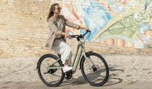 Una mujer monta una bicicleta eléctrica Fiido C700 en la calle.
