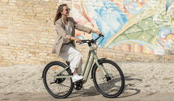 Una mujer monta una bicicleta eléctrica Fiido C700 en la calle.