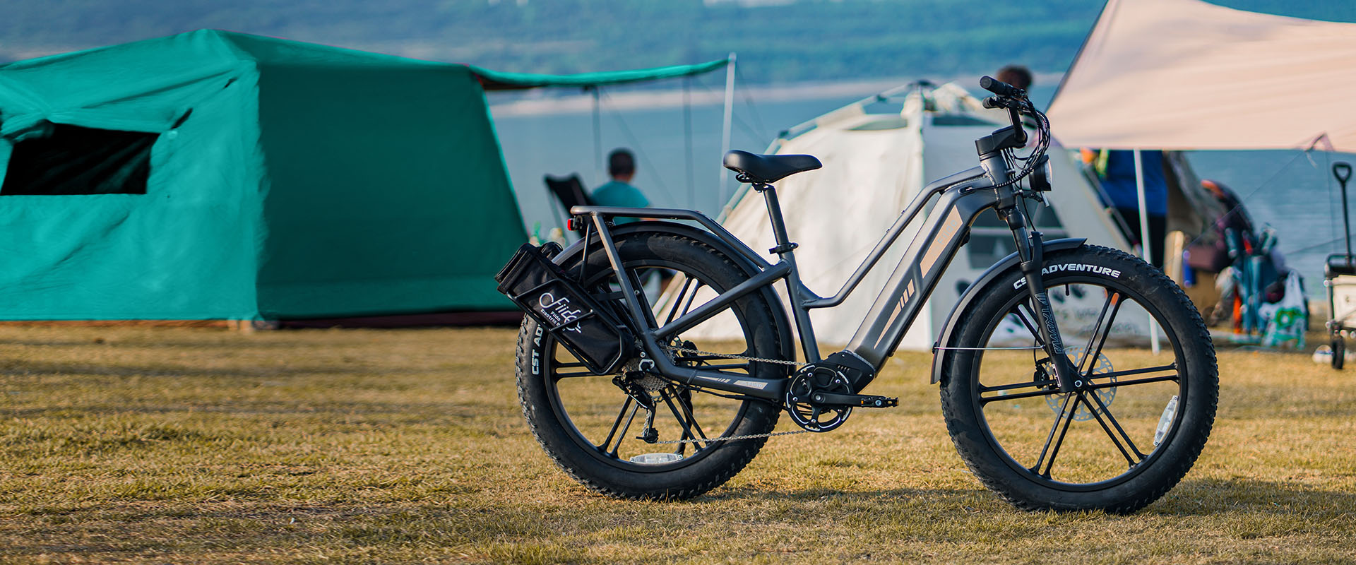 Una bicicleta eléctrica Fiido Titan está aparcada al lado de una tienda de campaña - pc