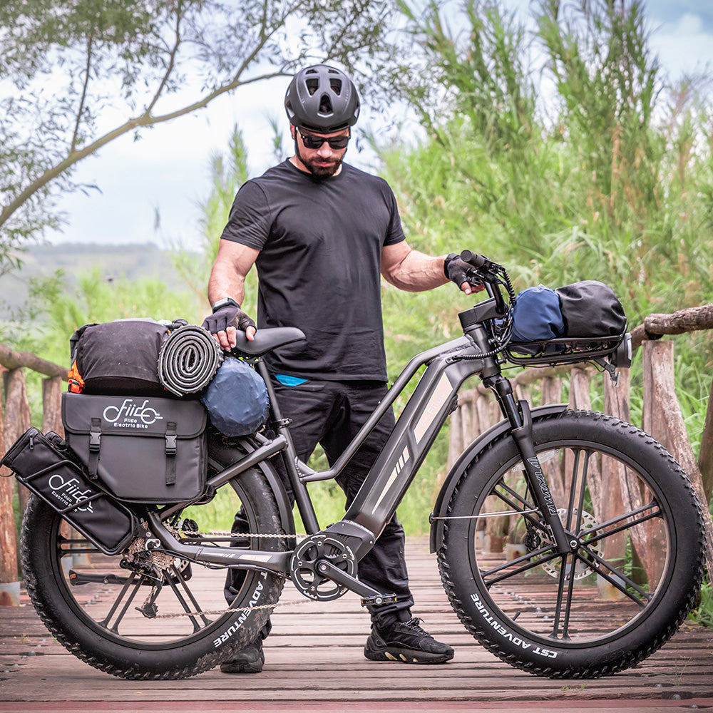 Hombre y Fiido Titan robusta bicicleta de carga eléctrica sobre un puente de madera