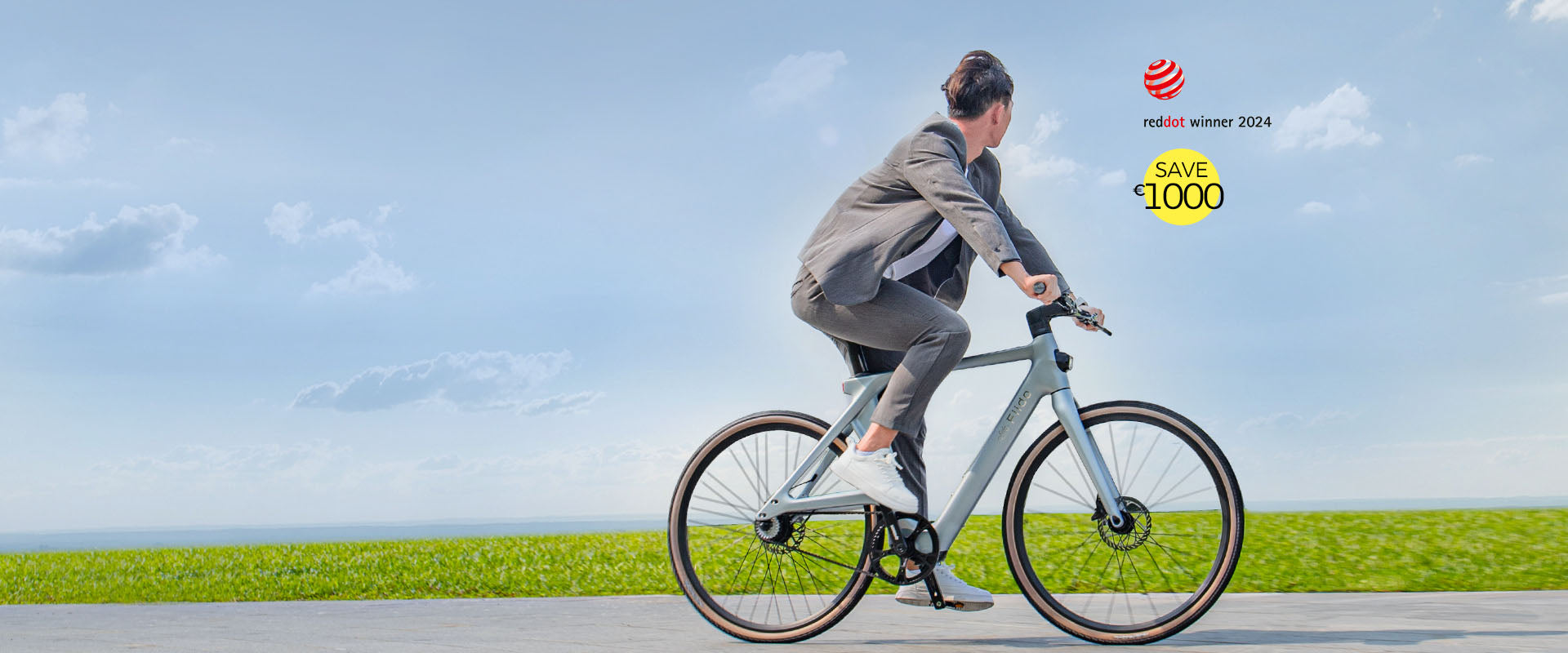 Un hombre con ropa gris monta una bicicleta eléctrica Fiido Air en la carretera - pc