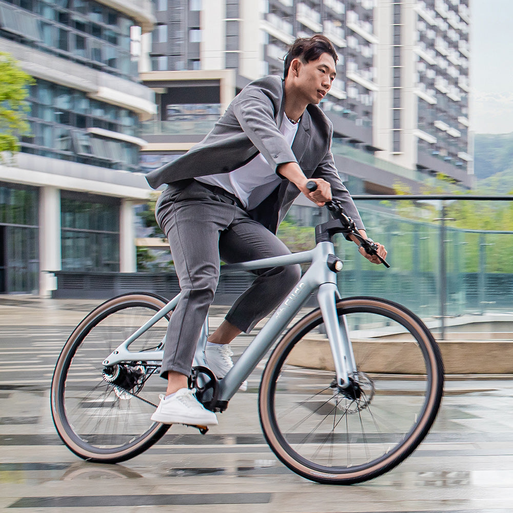 Hombre montando bicicleta eléctrica Fiido Air sobre suelo mojado