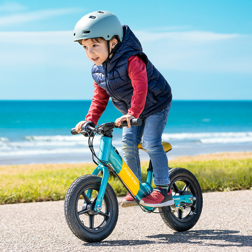 Un niño monta una bicicleta de equilibrio eléctrica Fiido Kidz